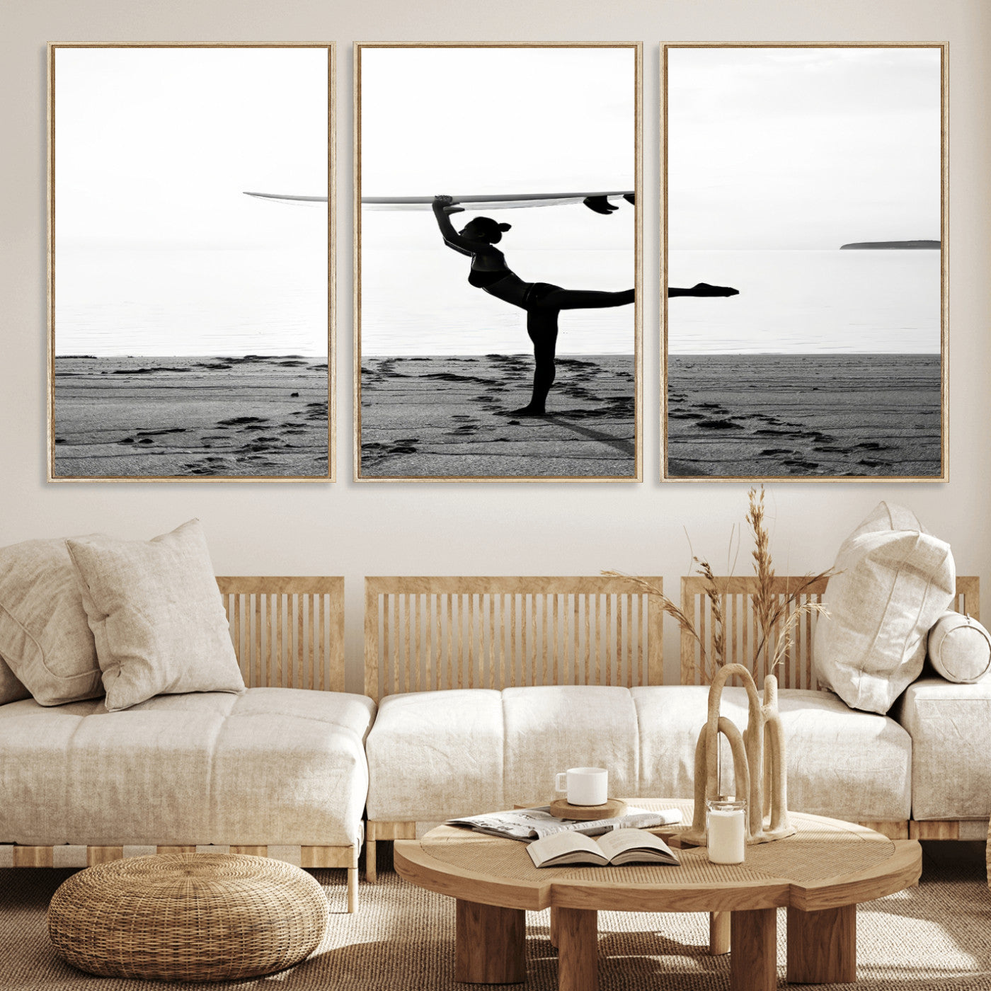 A woman balances a surfboard on her head while striking a yoga pose on the beach, silhouetted against a calm ocean horizon.
