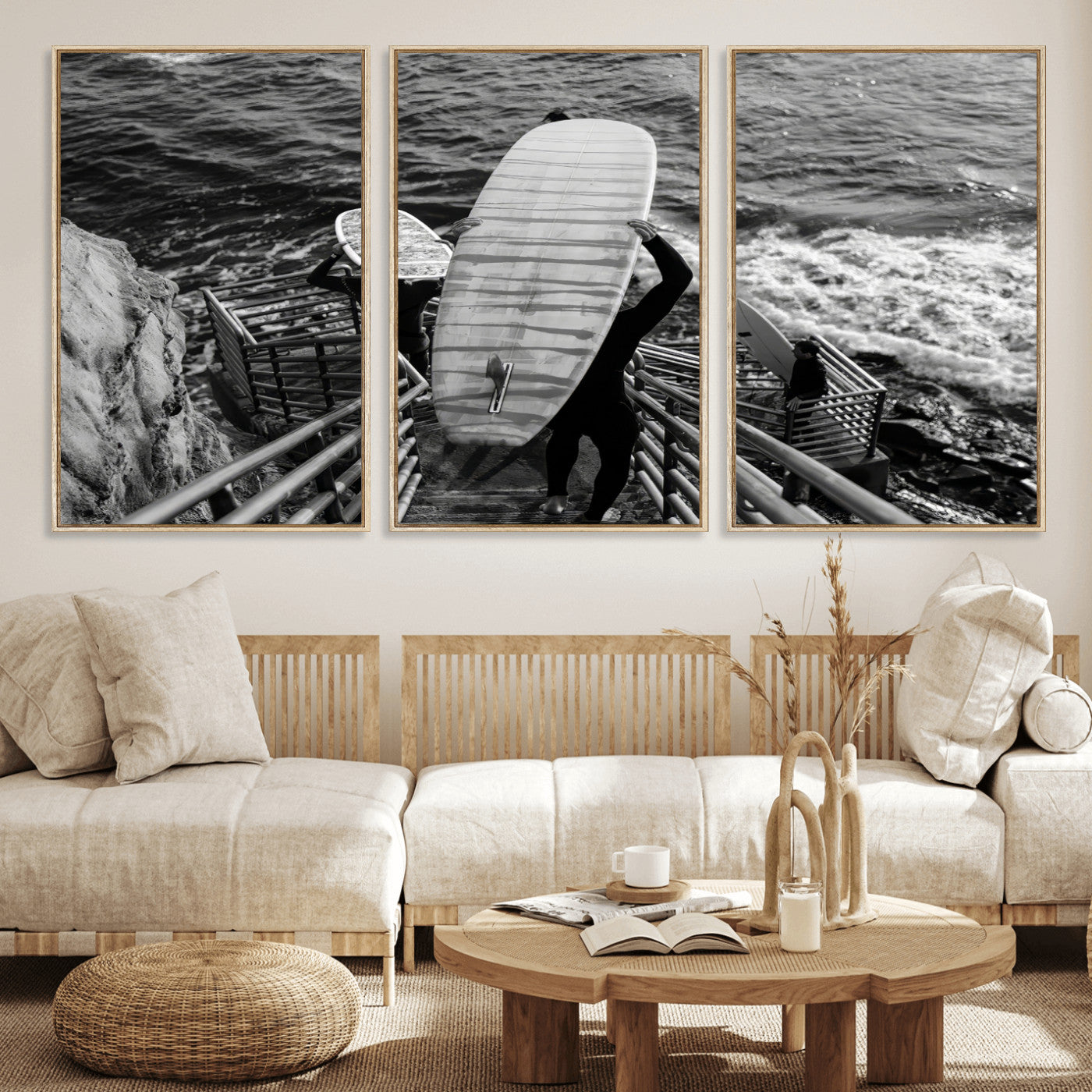 Black and white photo of surfers carrying boards down a rugged cliffside stairway, capturing a bold and adventurous coastal scene.