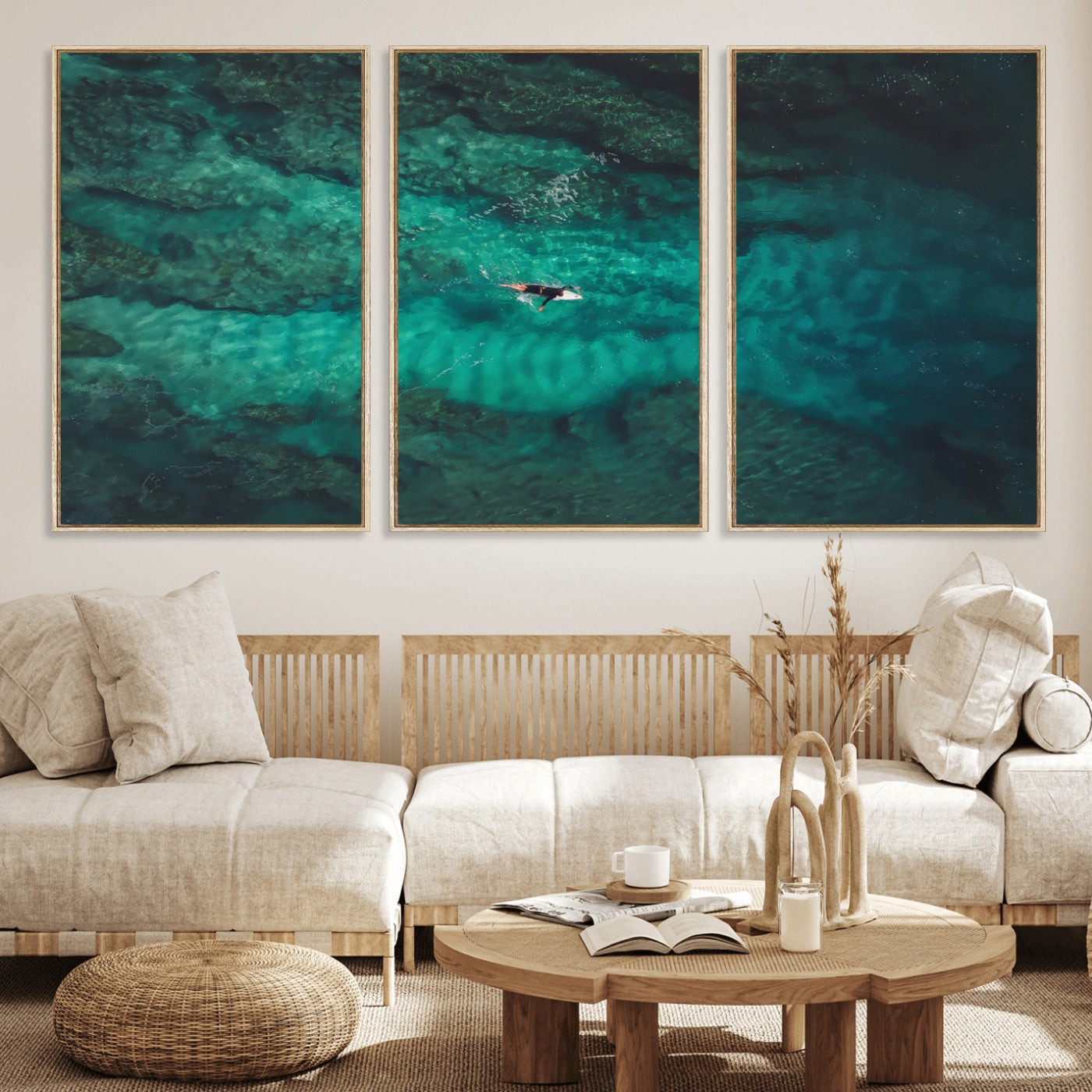 An aerial view of a solo surfer paddling through crystal-clear turquoise waters over a sunlit reef, capturing the beauty and serenity of open water surfing.