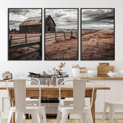 Framed canvas of a rustic barn under a moody sky with weathered fence and dark fields, ideal for farmhouse or rural-style wall decor.