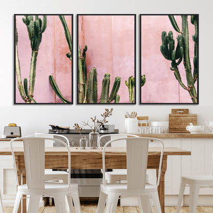 Framed canvas of tall green cacti against a soft pink wall, ideal for modern desert or colorful southwest-inspired home decor.