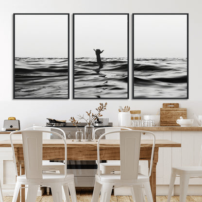 Black and white ocean with a hand making a surfer sign among dark waves, creating a dramatic and minimalist seascape with bold contrast.