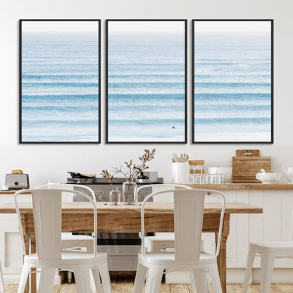 Minimalist ocean view with soft blue waves and a lone surfer, creating a serene and airy coastal aesthetic, perfect for tranquil home decor.