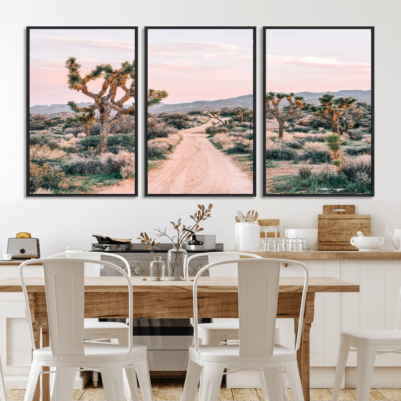 A dusty road winding through Joshua Tree National Park, framed by iconic twisted trees and warm desert tones under a soft pastel sky.