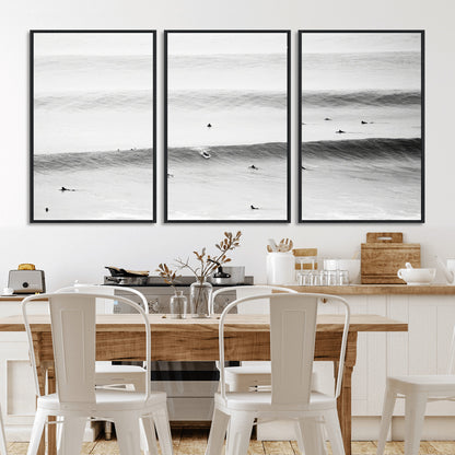 A monochrome photograph of swimmers gliding through gentle ocean waves, evoking a sense of calm and movement.