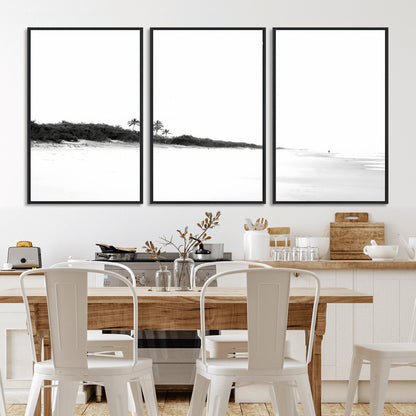 A black and white minimalist coastal scene with a vast open beach, distant palm trees, and a lone figure walking along the shoreline, evoking serenity and solitude.