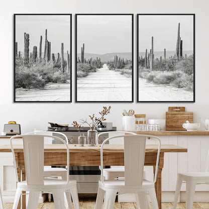 A black and white desert road stretching through a cactus-filled landscape, creating a rugged and timeless southwestern aesthetic with a sense of adventure.