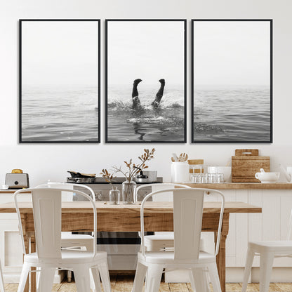 A black and white minimalist water scene capturing a playful splash as a swimmer dives upside down, creating a carefree and artistic aquatic aesthetic.