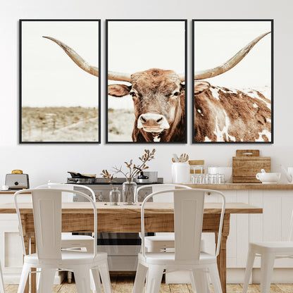 A Texas longhorn bull with wide horns, standing in a dry field under soft light, ideal for rustic farmhouse or western-themed interiors.