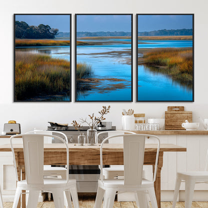 A peaceful marshland scene with calm blue water reflecting the surrounding grasses and trees, capturing the beauty of nature in a serene landscape.