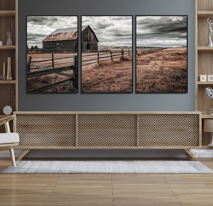 Framed canvas of a rustic barn under a moody sky with weathered fence and dark fields, ideal for farmhouse or rural-style wall decor.