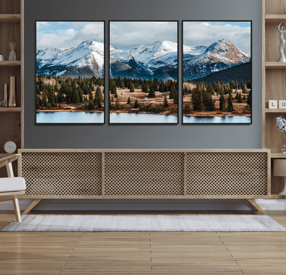 Framed canvas of snowy mountain peaks with pine forest and alpine lake, perfect for winter cabin or wilderness-inspired home decor.