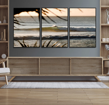 Photo of a surfer riding a golden hour wave at sunset, with tropical tones and dreamy light, perfect for tropical boho or coastal home decor.