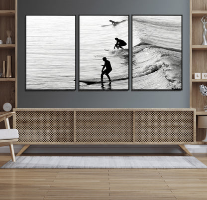 Black and white photo of surfers riding waves in a moody, high-contrast scene, ideal for modern coastal or surf-inspired home decor.