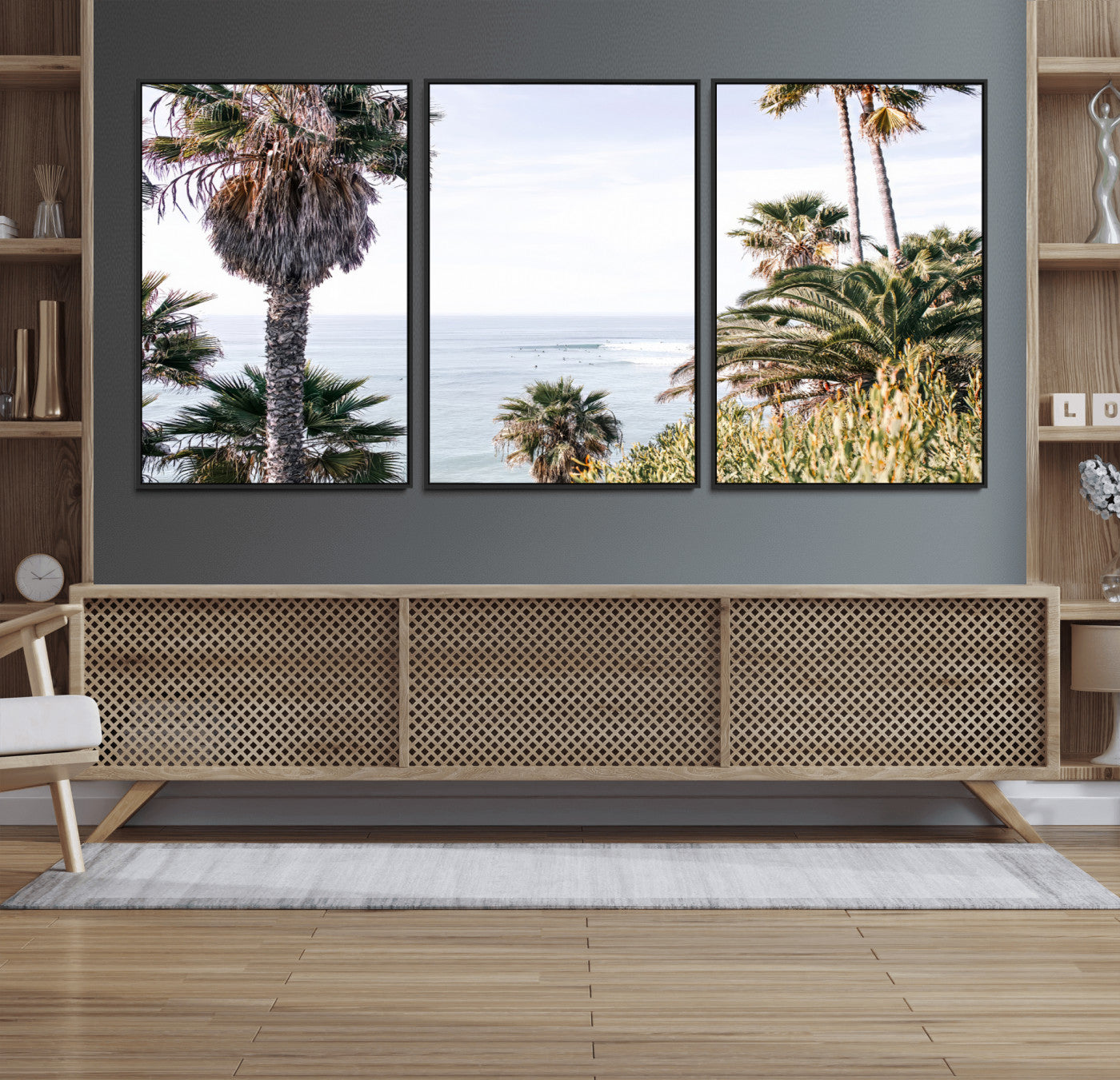 Scenic coastal view with tall palm trees overlooking a calm ocean, soft blue waves, and surfers in the distance, creating a peaceful tropical vibe.