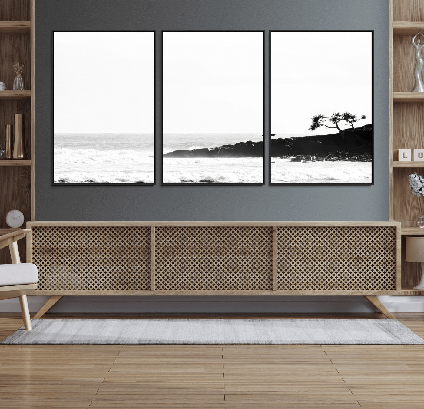 Black and white photo of a surfer standing on rocky cliffs, gazing at the waves, embodying the spirit of adventure and solitude.