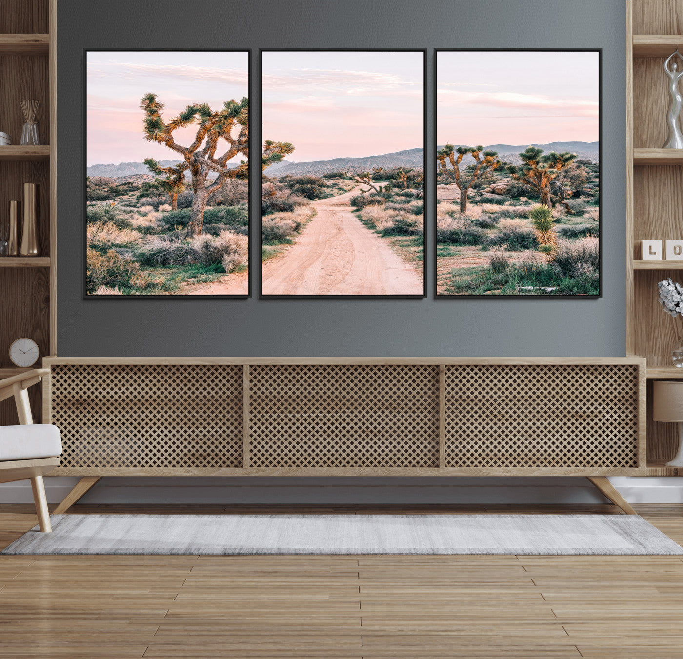 A dusty road winding through Joshua Tree National Park, framed by iconic twisted trees and warm desert tones under a soft pastel sky.