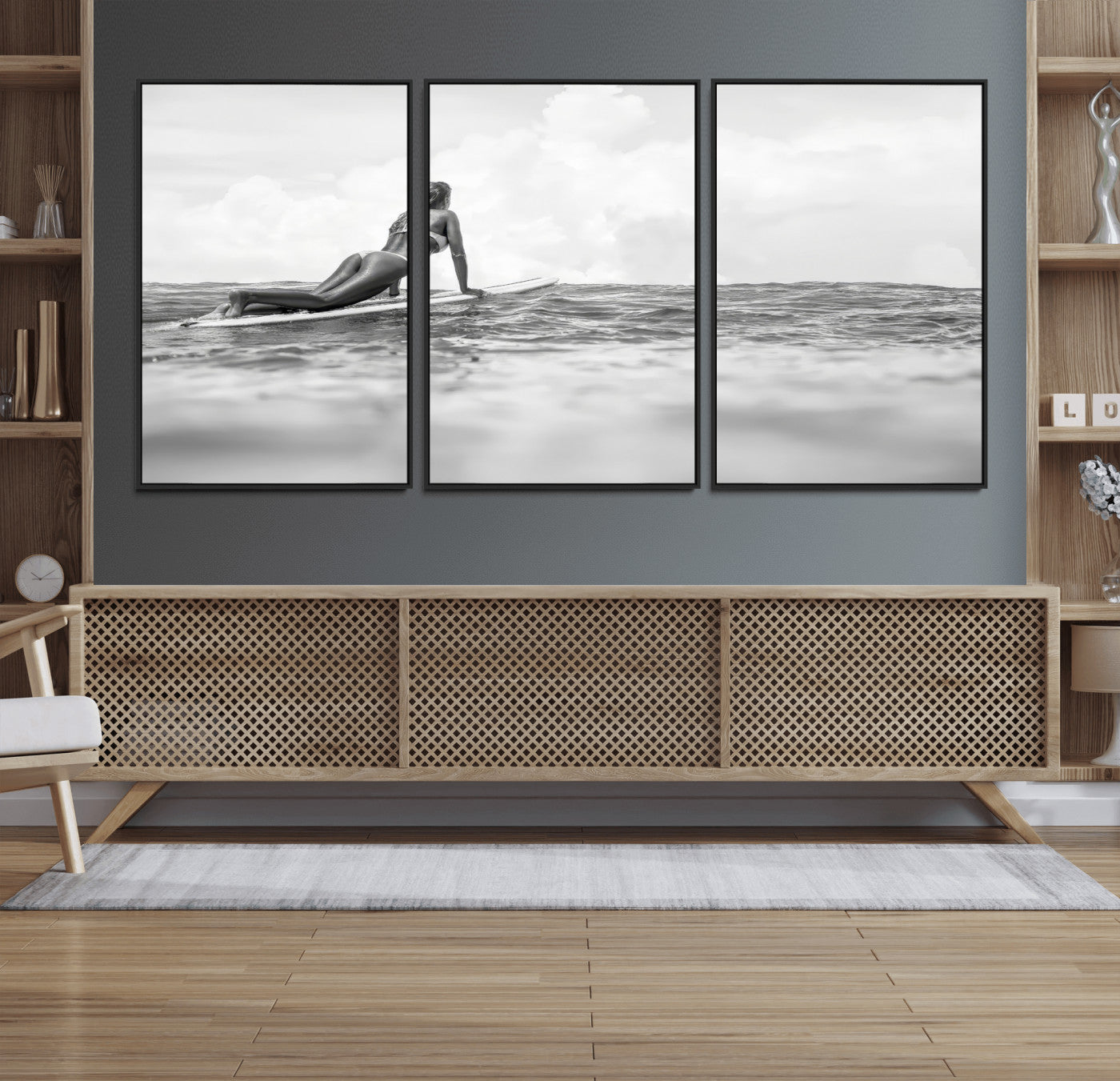 A black and white ocean scene featuring a surfer girl waiting on her board, gazing at the horizon, capturing a tranquil and adventurous coastal moment.