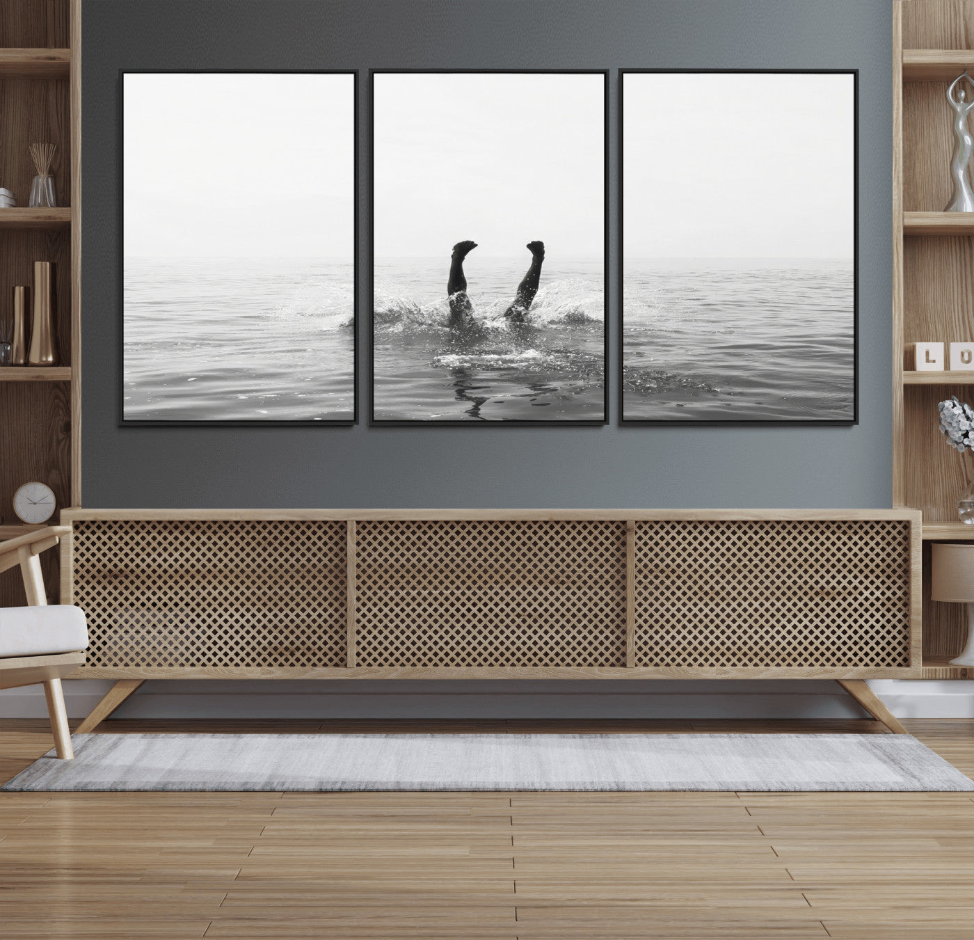 A black and white minimalist water scene capturing a playful splash as a swimmer dives upside down, creating a carefree and artistic aquatic aesthetic.