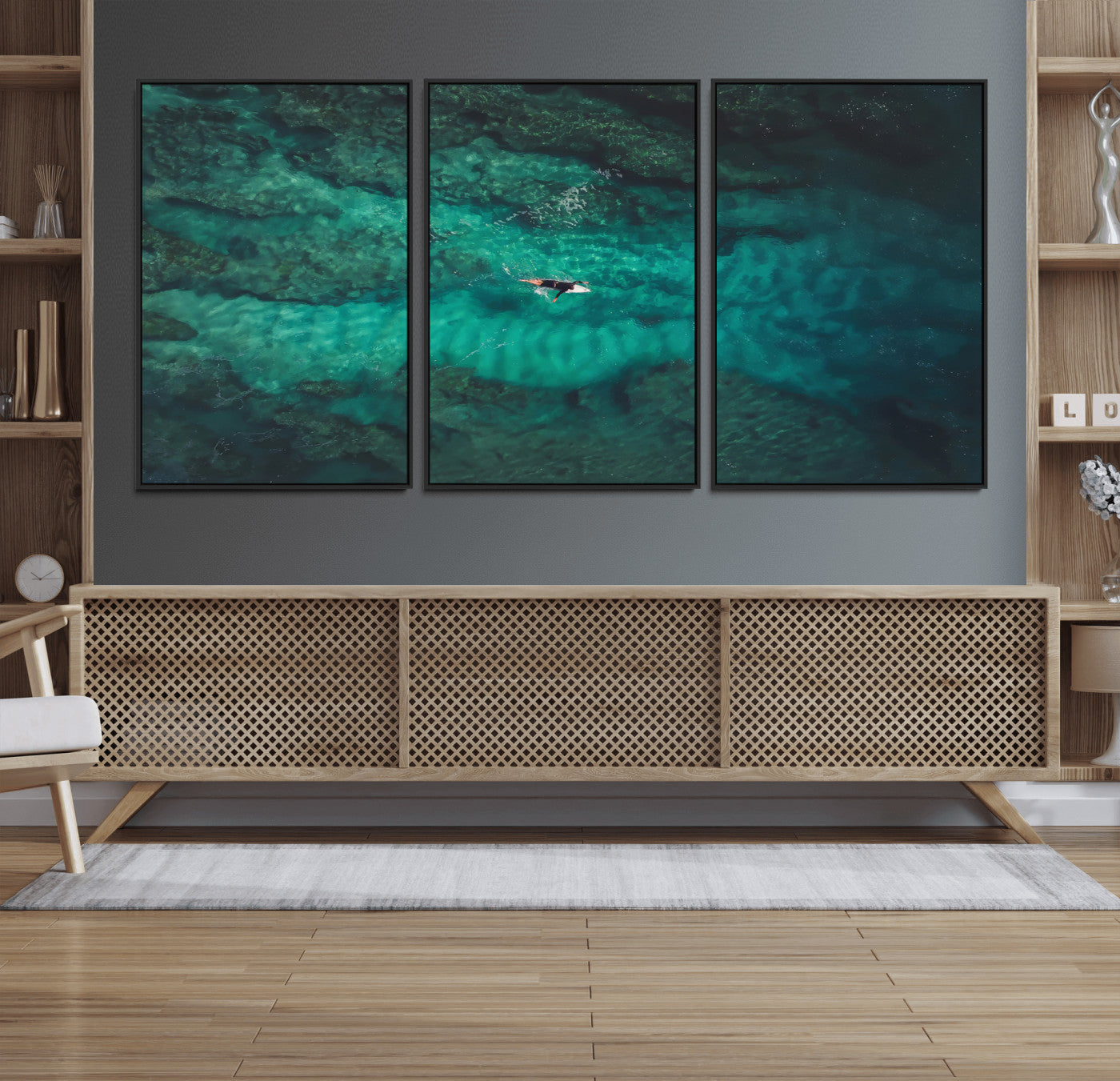 An aerial view of a solo surfer paddling through crystal-clear turquoise waters over a sunlit reef, capturing the beauty and serenity of open water surfing.