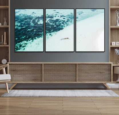 Canvas featuring an aerial view of a swimmer in shallow turquoise waters with coral patterns, ideal for tropical coastal home decor.