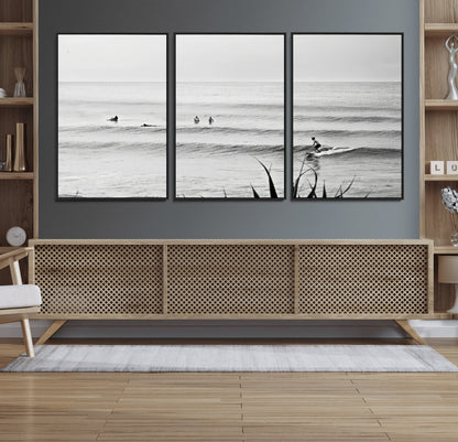 Monochrome canvas of surfers on calm ocean waves, ideal for minimalist coastal or beach-inspired interior decor.