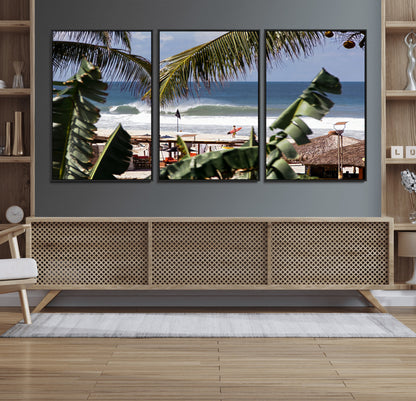 Canvas wall art of a tropical surf scene framed by palm trees, with a surfer on the shore and waves rolling in, ideal for beach-themed decor.