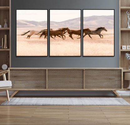 A herd of wild horses galloping through a sunlit desert plain with mountains in the background, perfect for rustic or western-themed wall decor.