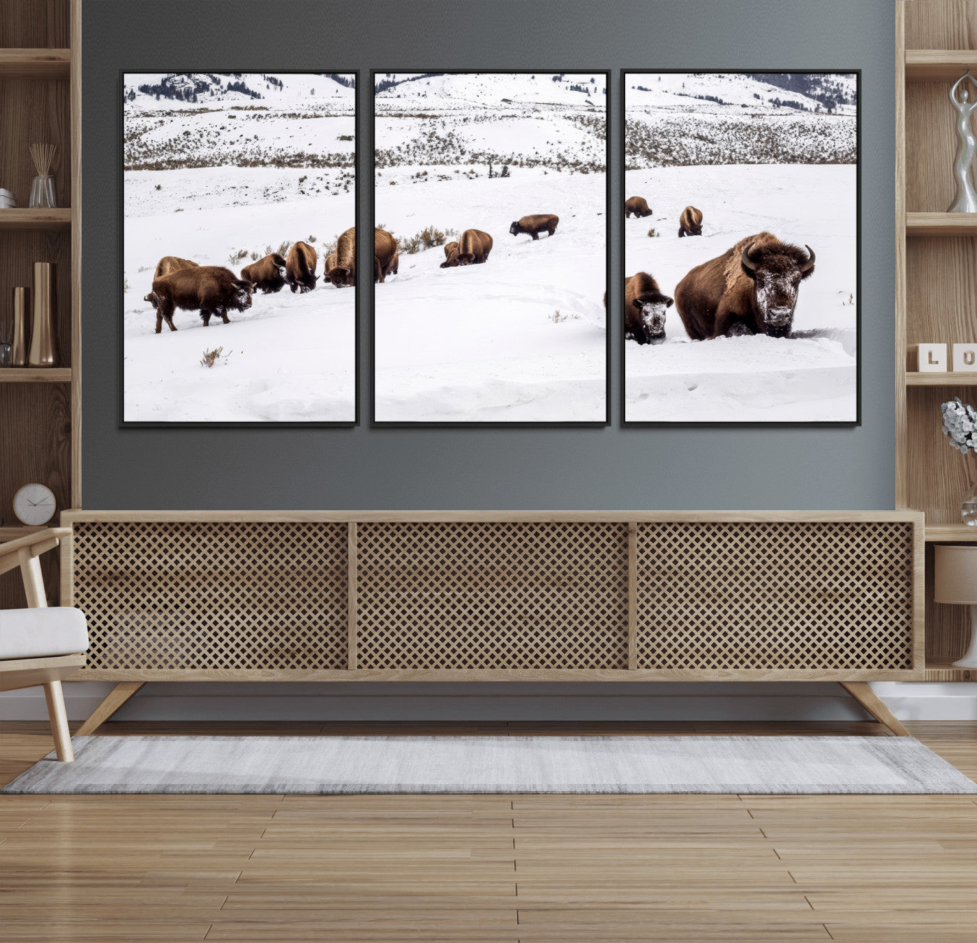 A herd of bison walking through deep snow in a mountain valley, perfect for rustic, cabin or western-themed wall decor.