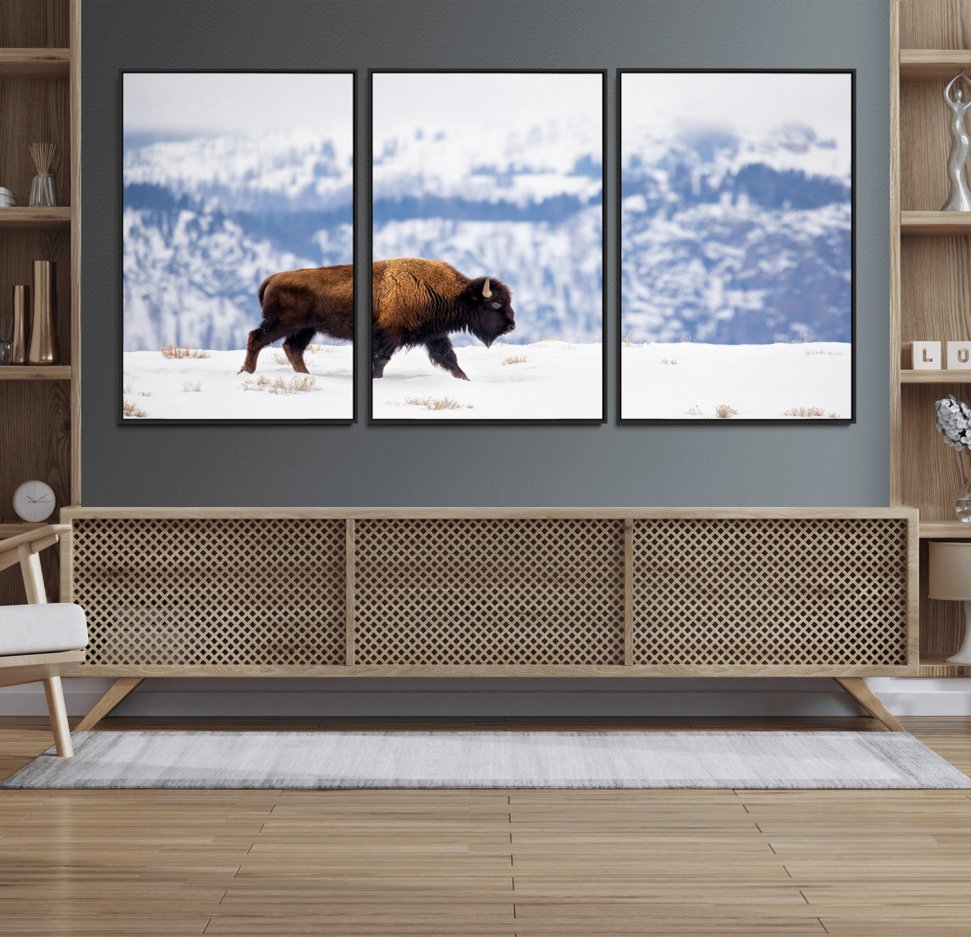 A lone bison walks across snowy ground with blue-toned mountain range behind, ideal for rustic or western farmhouse interiors.
