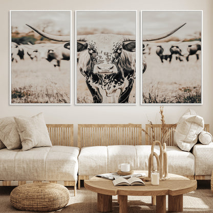 Canvas of a speckled Texas longhorn standing boldly in a field with a herd behind, perfect for rustic western or farmhouse wall decor.