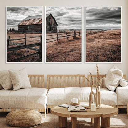 Framed canvas of a rustic barn under a moody sky with weathered fence and dark fields, ideal for farmhouse or rural-style wall decor.