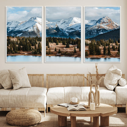 Framed canvas of snowy mountain peaks with pine forest and alpine lake, perfect for winter cabin or wilderness-inspired home decor.