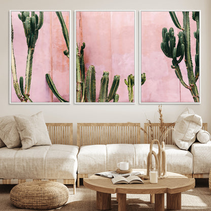 Framed canvas of tall green cacti against a soft pink wall, ideal for modern desert or colorful southwest-inspired home decor.