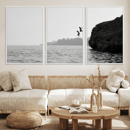 Black and white canvas of two figures cliff jumping into the sea, captured with moody tones, ideal for modern coastal or adventure-themed home decor.   2/2