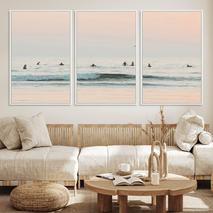 Dreamy photo of surfers waiting on soft pastel waves under a pink sunset sky, ideal for soft coastal minimalist or serene ocean-themed home decor.