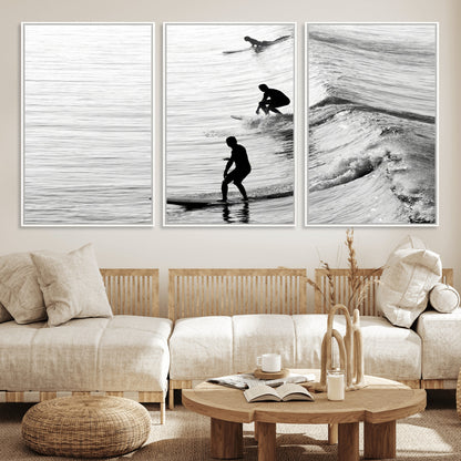Black and white photo of surfers riding waves in a moody, high-contrast scene, ideal for modern coastal or surf-inspired home decor.