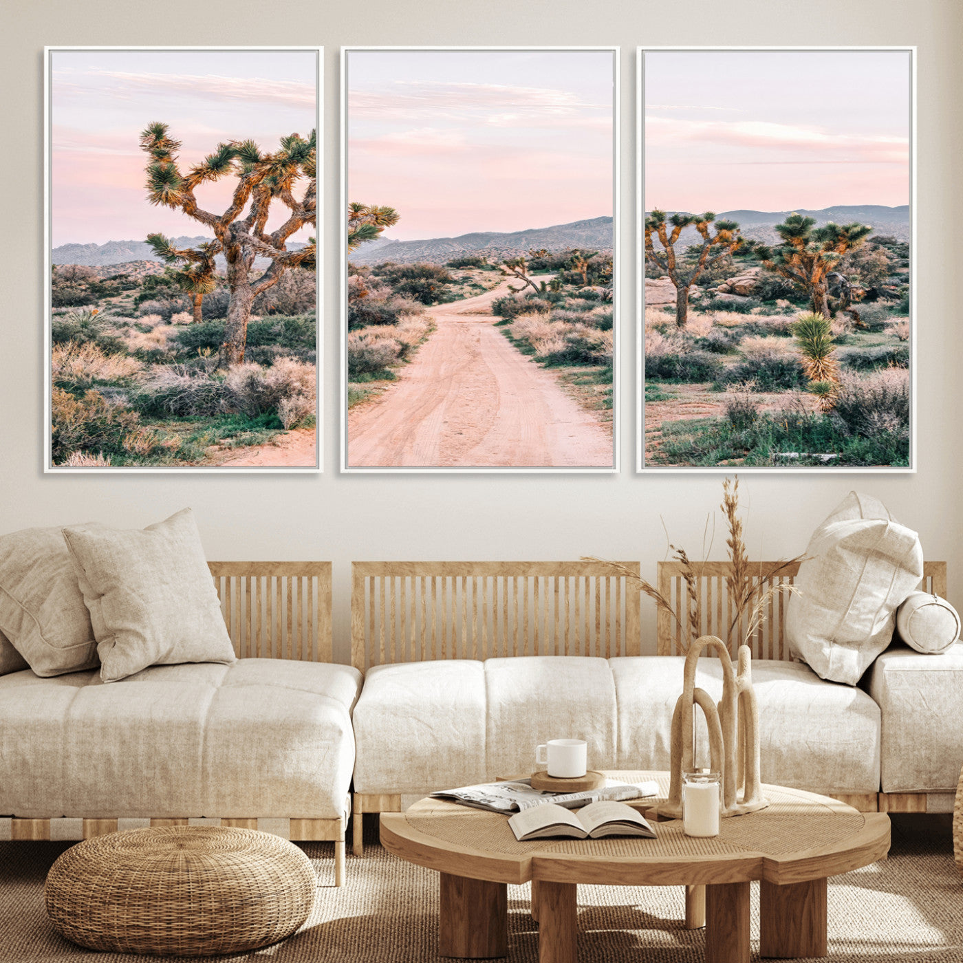 A dusty road winding through Joshua Tree National Park, framed by iconic twisted trees and warm desert tones under a soft pastel sky.