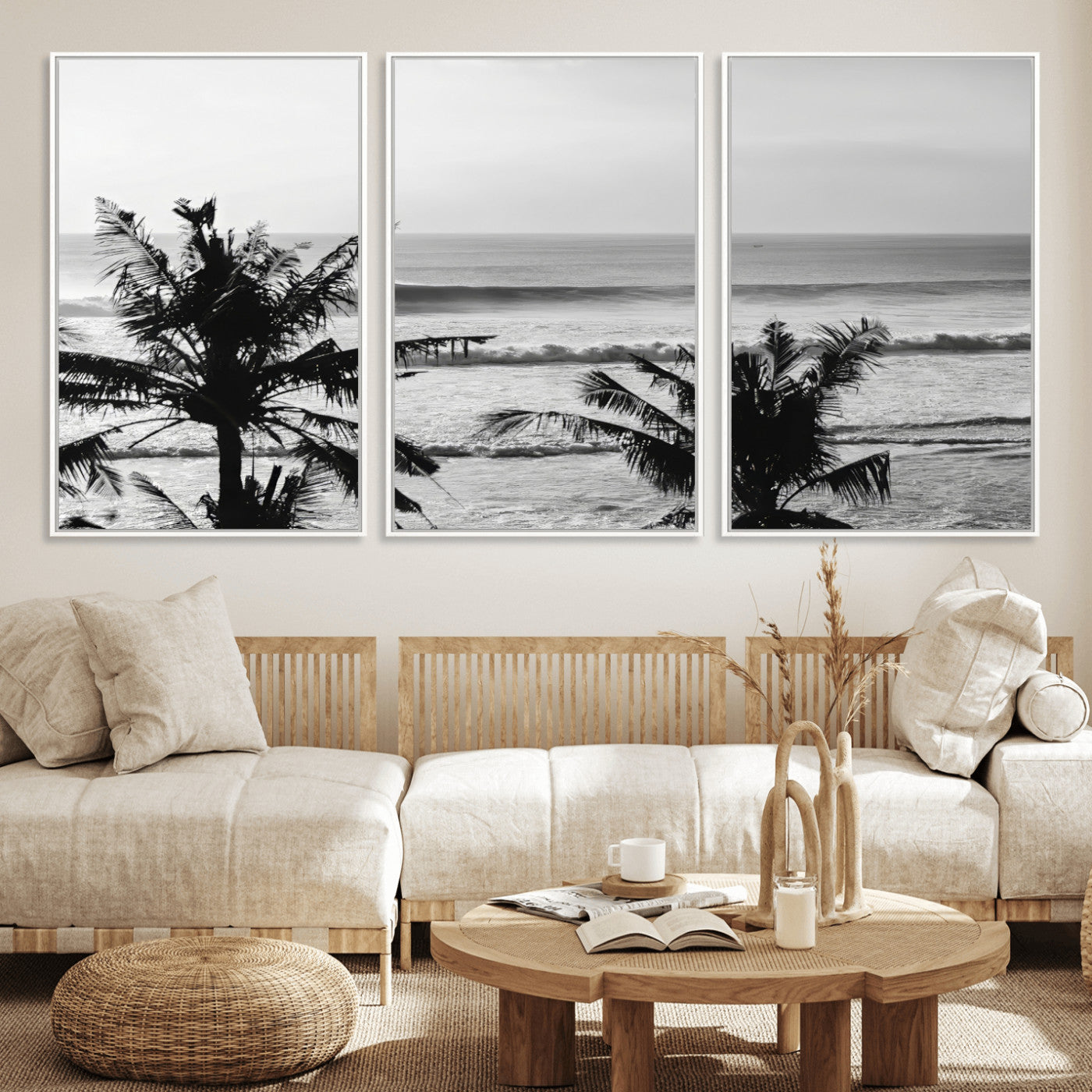 Black and white view of ocean waves crashing on a tropical coastline, framed by silhouetted palm trees under a vast, open sky.