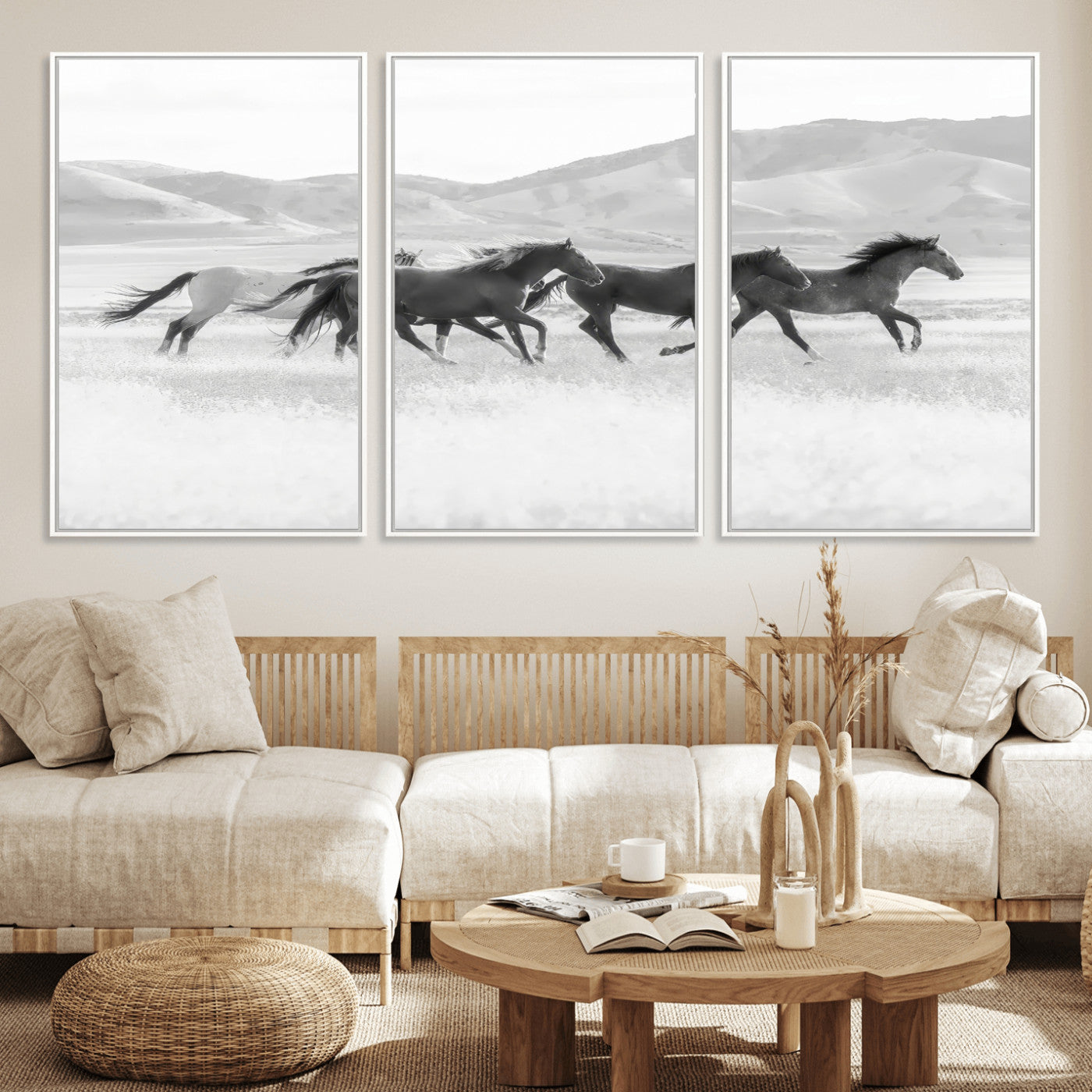 A black and white image of wild horses running freely across an open grassland, capturing the power and beauty of untamed nature in a rustic western setting.