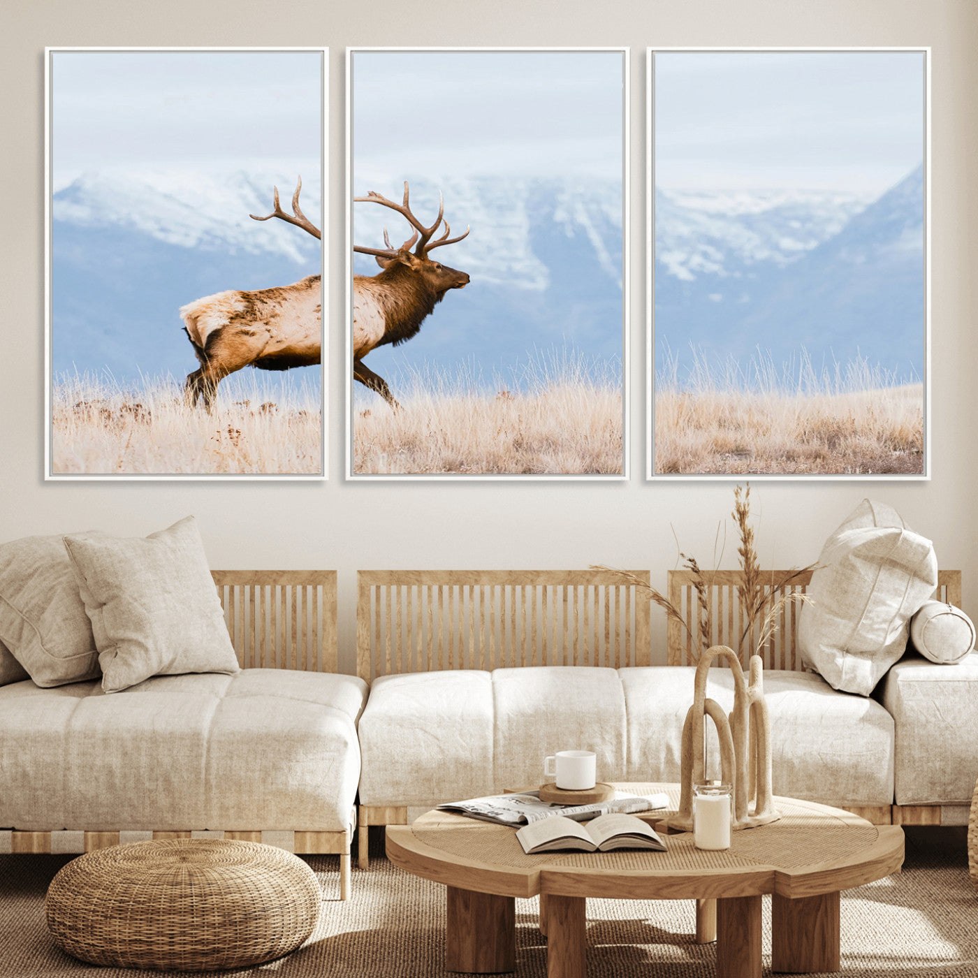 An elk walking on snowy grassland with majestic mountains in the background, ideal for rustic lodge or cabin wall decor.
