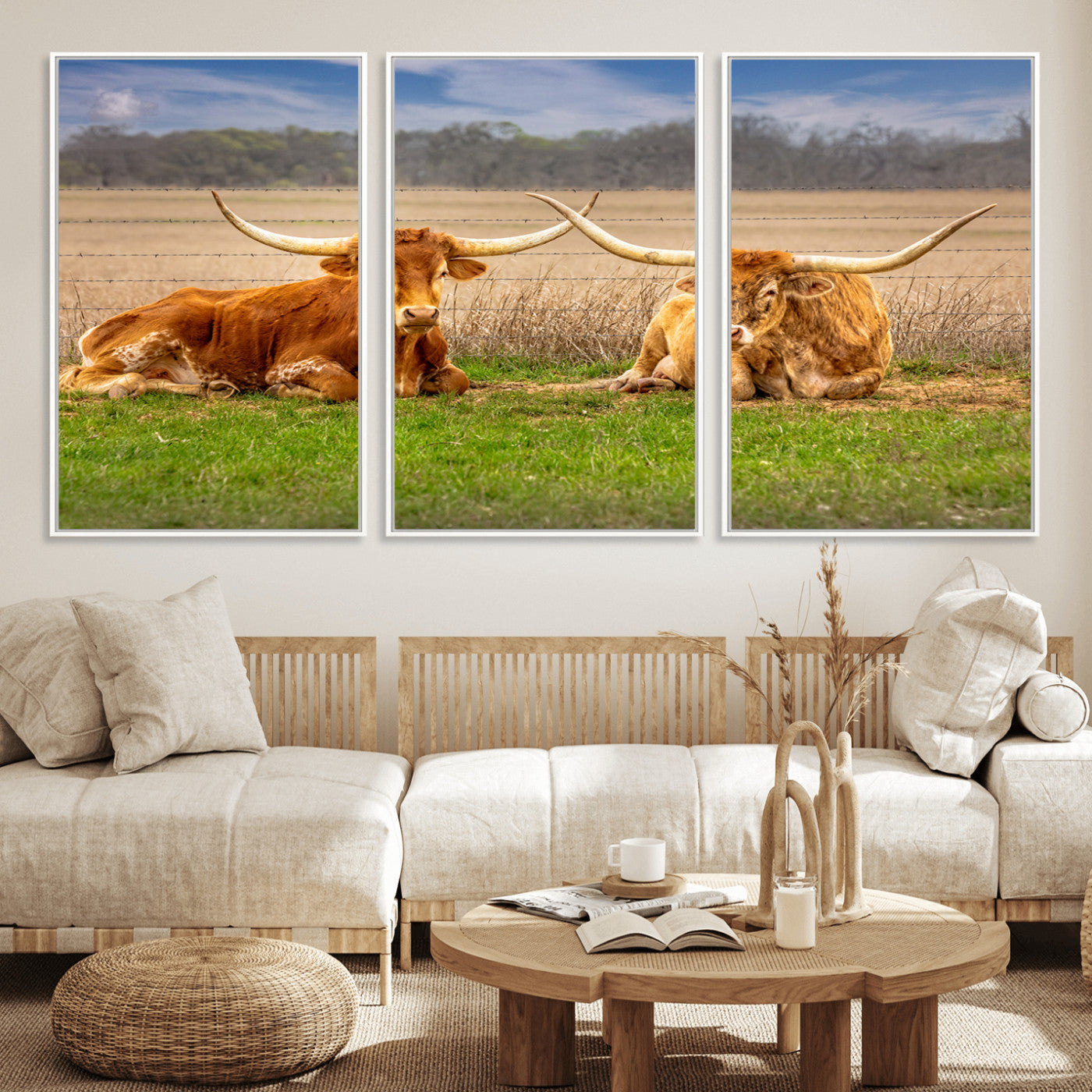 Two longhorn cows lying on green grass in front of a golden field and trees under a blue sky, perfect for rustic country wall decor.