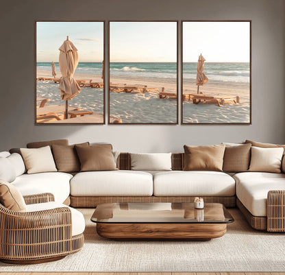 Minimalist photo of empty beach loungers and umbrellas on soft sand, ideal for calm seaside or pastel coastal-style home decor.