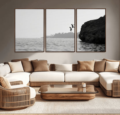 Black and white canvas of two figures cliff jumping into the sea, captured with moody tones, ideal for modern coastal or adventure-themed home decor.   2/2