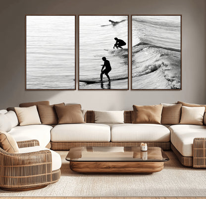 Black and white photo of surfers riding waves in a moody, high-contrast scene, ideal for modern coastal or surf-inspired home decor.