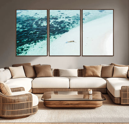 Canvas featuring an aerial view of a swimmer in shallow turquoise waters with coral patterns, ideal for tropical coastal home decor.