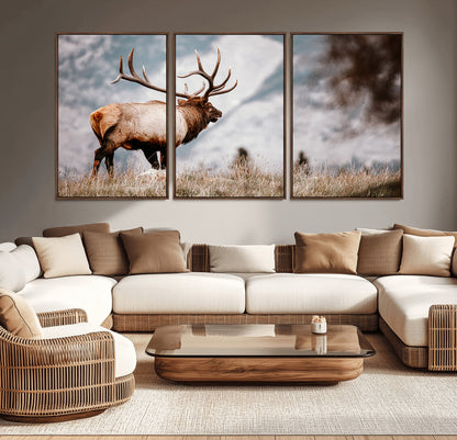 Majestic elk with large antlers standing in grass with snowy mountains in background, perfect for rustic cabin or lodge style decor.