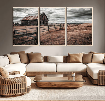 Framed canvas of a rustic barn under a moody sky with weathered fence and dark fields, ideal for farmhouse or rural-style wall decor.