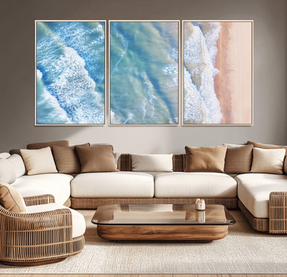 Aerial photo of soft blue waves meeting sandy shore, perfect for modern coastal or beach-themed decor with a light and tranquil aesthetic.