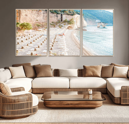 Wall art of a calm Mediterranean beach with rows of sun loungers and umbrellas in soft pastel tones, perfect for light coastal or vacation-themed decor.